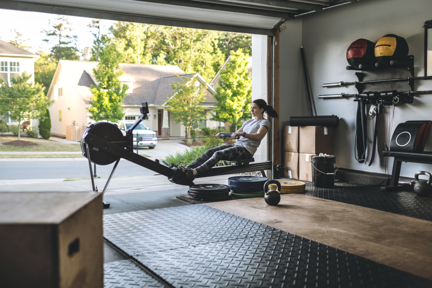 A woman working out on a rowing machine inside her garage
