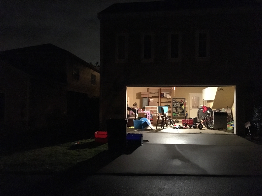A house in the night with its garage open and working tools inside